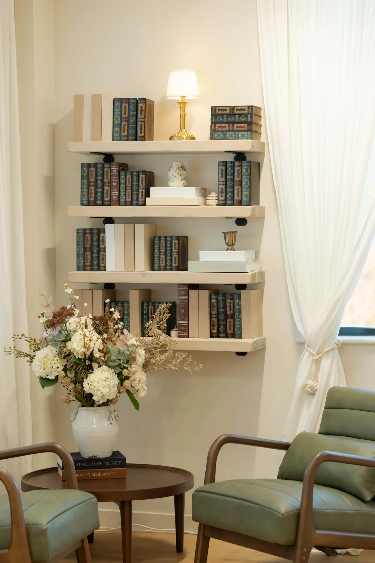 Reading corner with green armchairs and tall bookshelf